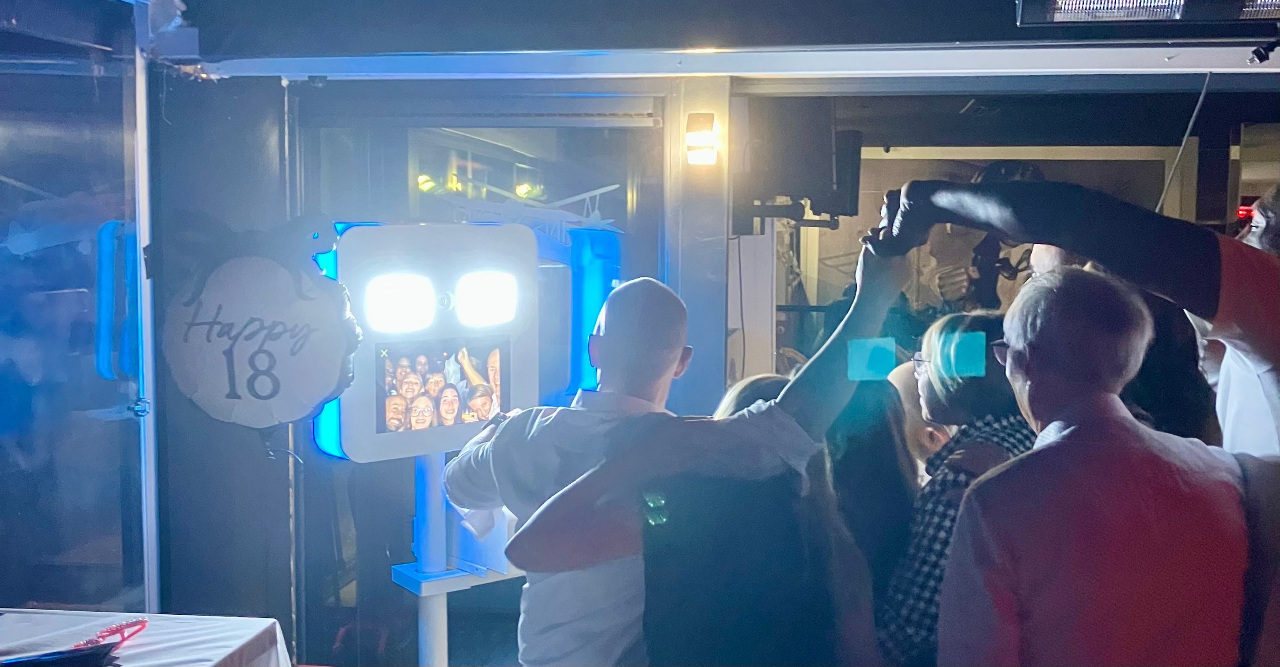 Groupe d’invités utilisant un photobooth lors d’un événement.