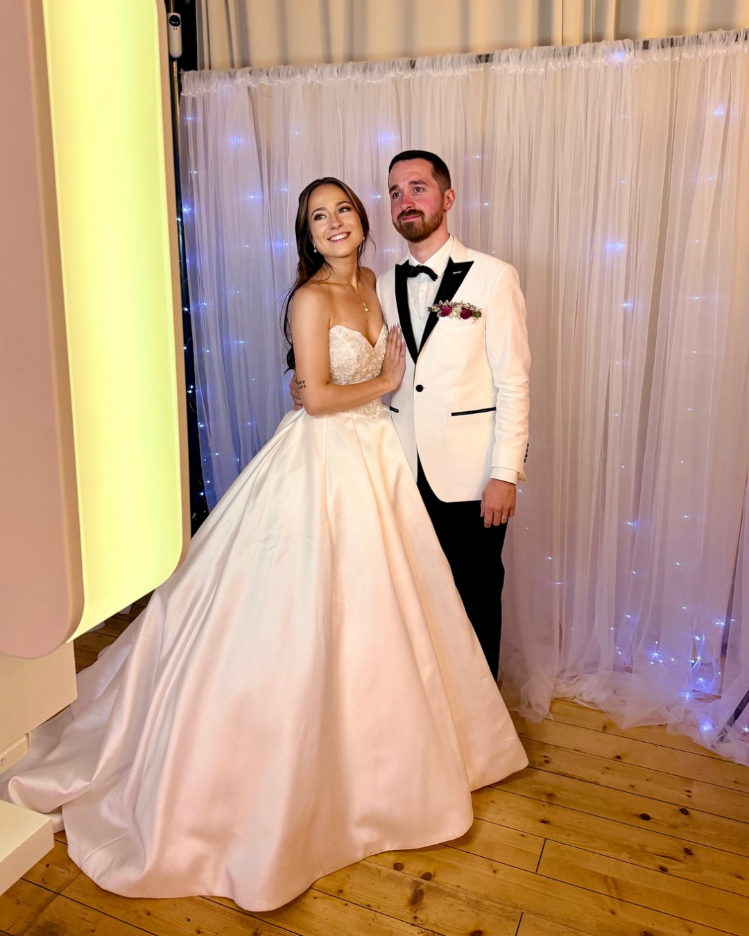 Mariés devant un photobooth lors d'un mariage en Île-de-France.